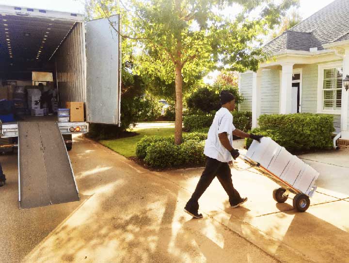 Professional movers carefully unloading furniture from a moving truck, ensuring safe and efficient relocation services.