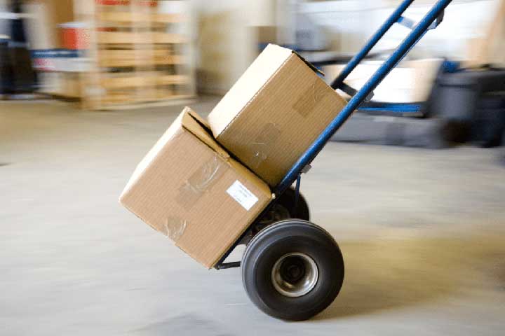 Blue moving dolly in motion with two stacked boxes, highlighting efficient moving services.